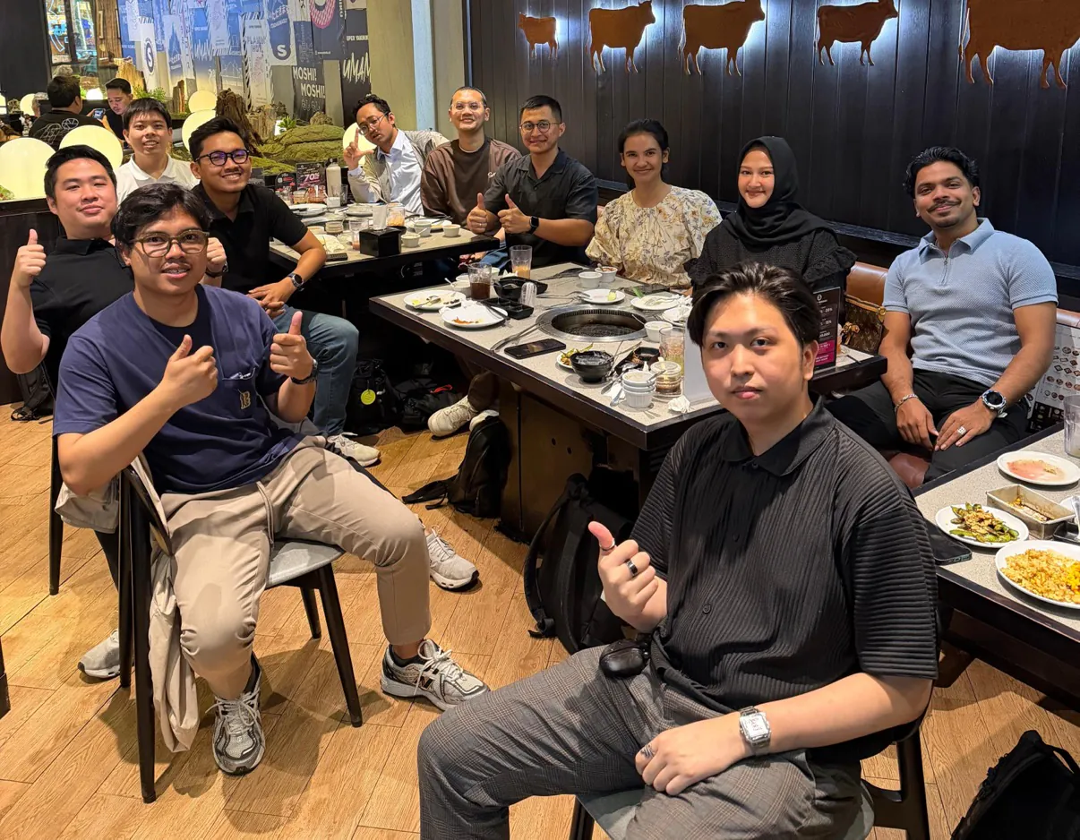 Locus colleagues giving a thumbs-up at a team dinner