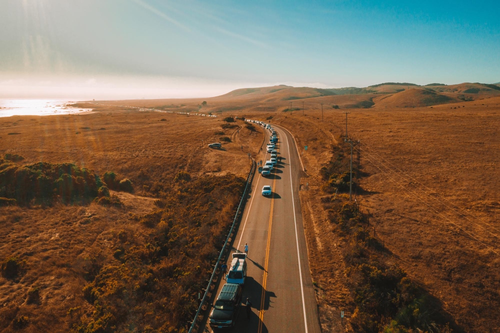 Aerial view of vehicles on a winding rural road.