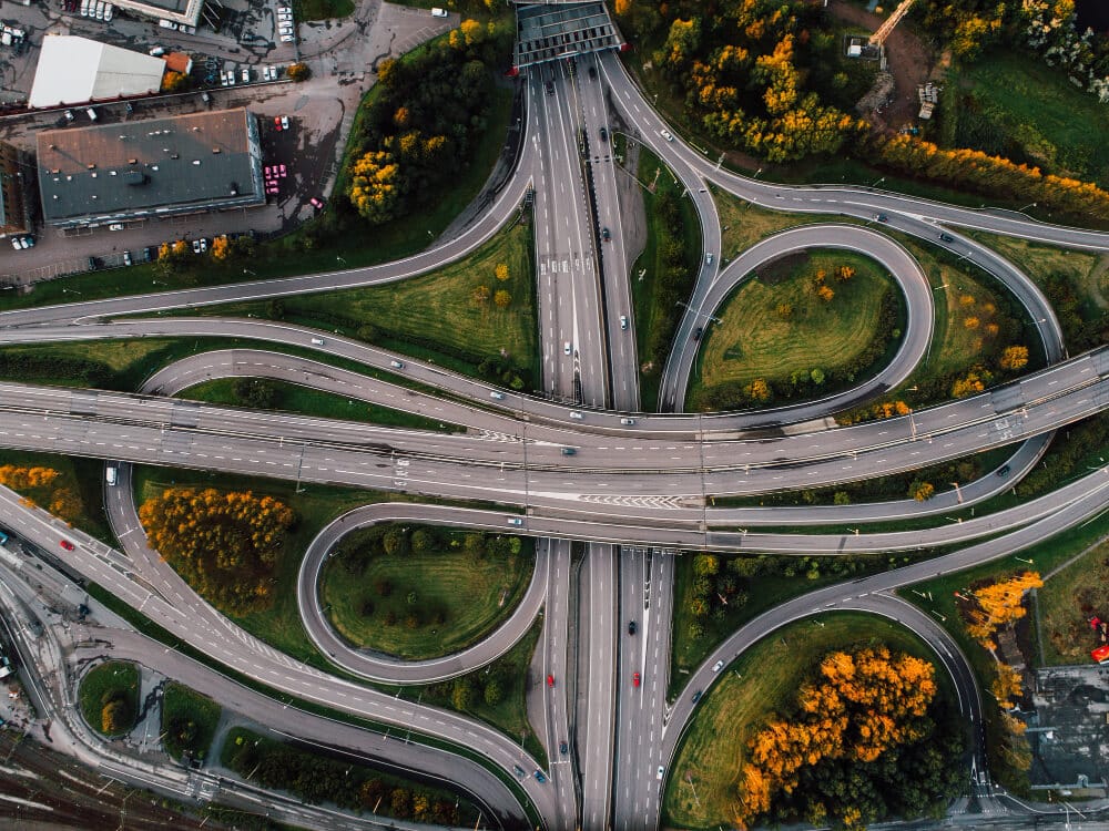 Aerial view of a complex highway interchange with curved ramps and green medians