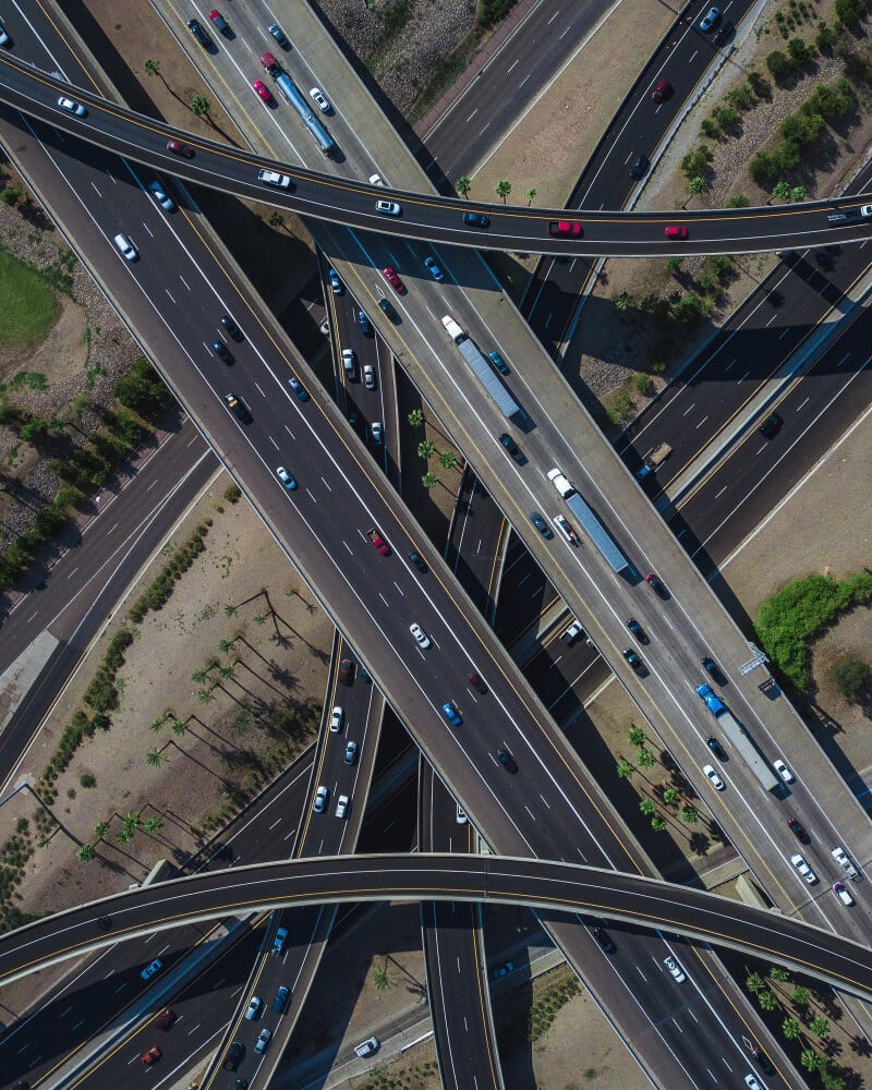 Aerial view of a large urban intersection with complex vehicle movement and lane markings.