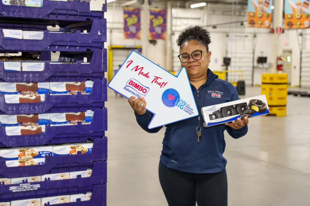 Bimbo Bakeries employee presenting freshly baked bread at the production facility
