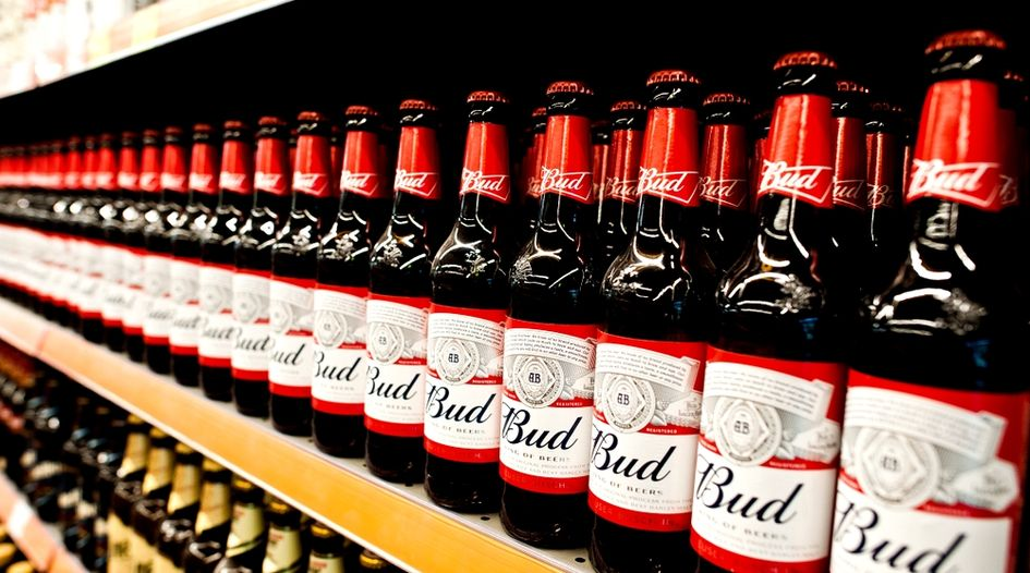 Budweiser beer bottles neatly stocked on retail store shelves