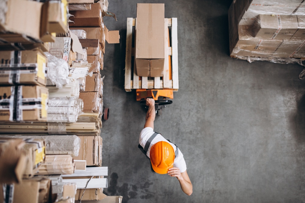 Young warehouse worker arranging boxes in the supply center