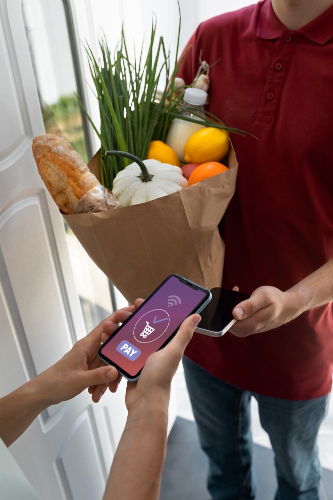 Customer paying for groceries using a smartphone during a delivery handoff.